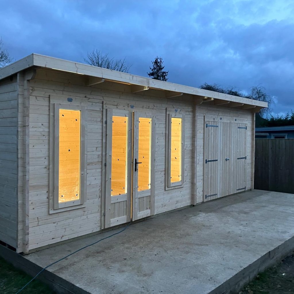 Finished timber studio and workshop space with double doors and windows and illuminated interior