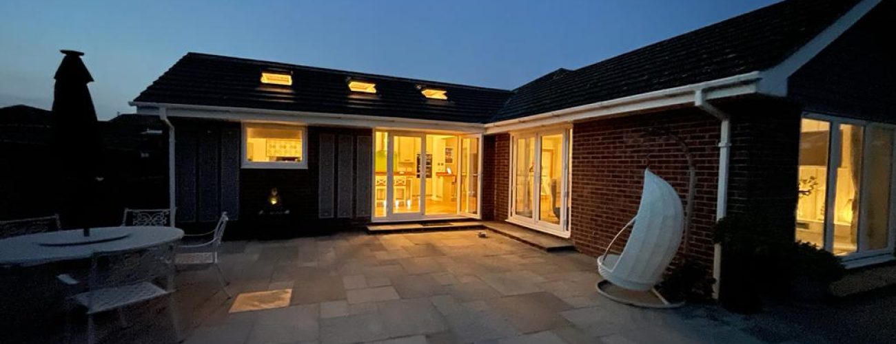 Exterior of bungalow at night with lights on