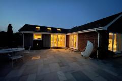 Exterior of bungalow at night with lights on