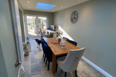 Dining area with table and chairs, slate tile floor and patio doors to rear garden