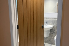 View of bathroom with extra wide timber door