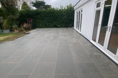 Large patio area with steps down to lawn