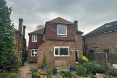 Second storey extension with patio and plants on gravel drive